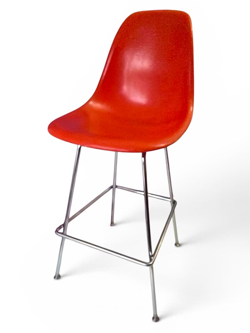 Orange fibreglass shell bar stool on a steel base, three-quarter view