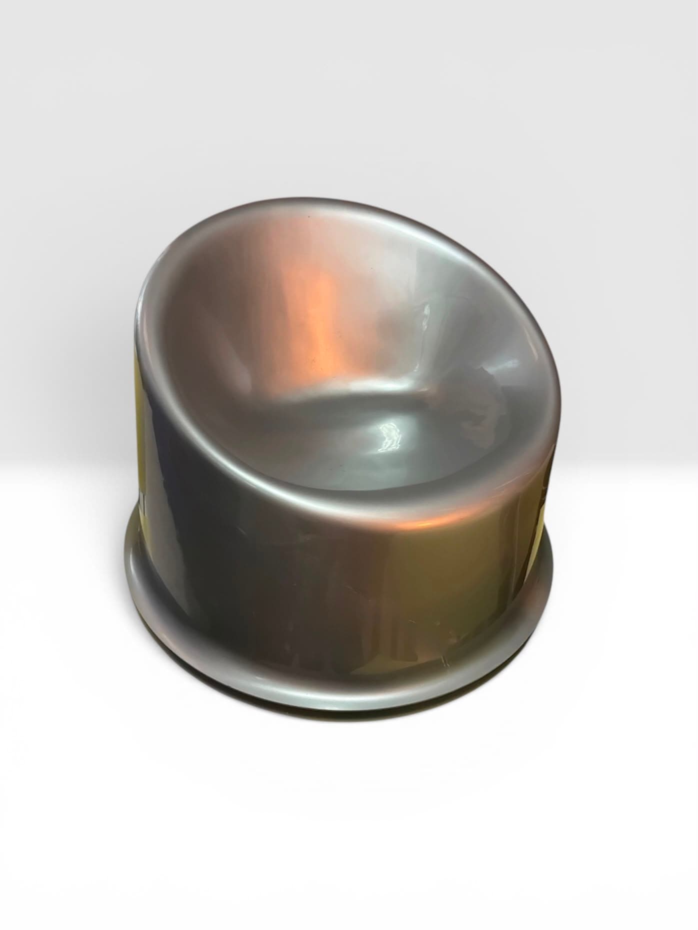 Metallic silver moulded tub chair on a round plinth base, three-quarter view